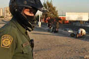 A border patrol agent surveys the San Ysidro border, the international boundary separating San Diego from Tijuana. While this agent travels on an ATV, other perform checks on foot or via helicopter.
