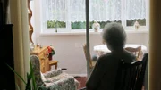 Oma schaut aus dem Fenster.