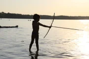 Ein Kind beim Fischen mit Pfeil und Bogen im brasilianischen Bundesstaat Mato Grosso im Amazonas-Gebiet.