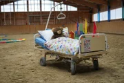 Ein Kinderkrankenbett in der Reithalle des Lichtblickhofes