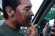 Laredo, TX: An agent painting his face in camouflage before a mission.