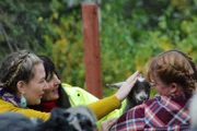 L-R: Katie und Mollee streicheln eine Ziege, die von ihrem alten Besitzer gehalten wird.