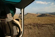 Texas Game Warden in the passenger side of a helicopter.