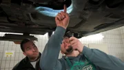 Ein Automechaniker inspiziert ein Auto.