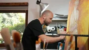 Tim Ernst in seinem Atelier, während er die Kopie des Werkes „Selbstbildnis am 6.Hochzeitstag“ von Paula Modersohn- Becker anfertigt.