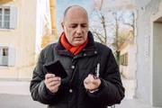 Hubert (Bernhard Ulrich) findet überrascht Gregors Handy und Geldbeutel in seinem Auto.