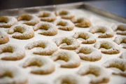 Die fertig gebackenen und gezuckerten Vanillekipferl auf einem Blech.