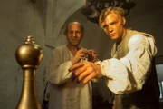Ein Kegel aus Holz hat sich in Gold verwandelt. Der Schuster (Bernd Michael Lade, l.) und Erik (David Schütter, r.) wundern sich.