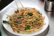 Phnom Pens beliebtestes Fastfood ist „Lort Char“, eine rauchige Mischung aus kurzen Reisnudeln, Rindfleisch und Gemüse, gebraten in Austern und gesüßten Sojasaucen, garniert mit einem Spiegelei.