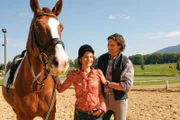 Sekretärin Miriam Stockl (Marisa Burger) genießt den Unterricht bei Reitlehrer Philipp Stumpfegger (Jost Pieper).