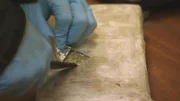 El Paso, TX: An officer opening a confiscated package, which is filled with marijuana.