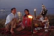 Nicolas (Patrik Fichte) und Julia (Jeanne Tremsal) genießen ihr Dinner am Strand.