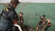 Zivilbeamte beschlagnahmen ein illegales Fischernetz im Meer von Cádiz.