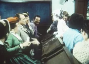 Entsetzt müssen Mrs. (Katherine MacGregor, l.) und Mr. Oleson (Richard Bull, 2.v.l.) erleben, wie ihr Willie (Jonathan Gilbert) von der Bühne stolpert.