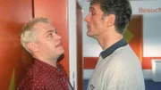 Tim (Oliver Reinhard, li.) überbringt Dr. Schmidt (Walter Sittler) die Nachricht, dass die Überwachungskamera im Aufzug ausgefallen ist. Gut für Dr. Schmidt, der im Aufzug seine Lockerungsübungen gemacht hat...