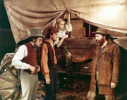 Dr. Battius (Gabriel Gason, l.) versucht, den jungen Bush (r.) zu beruhigen, der sich mit Paul Hover (Robert Benoit, 2.v.l.) um seine Cousine Ellen Wade (Catherine Jourdan) anlegen will.