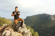 Albert Lin posiert für ein Porträt, während er die Überreste eines vergessenen kanaanitischen Außenpostens in den Bergen von Ein Tamir, Israel, erkundet.