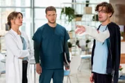 Dr. Ruhland (Gunda Ebert, l.) und Mikko (Luan Gummich, M.) sorgen sich um ihren Patienten Lars Wexler (Leonard Fuchs).