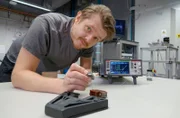 Erfinder Dimitri Benke aus Darmstadt hält das magnetisches Kühlsystem für Kühlschränke in seinen Fingern.