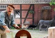 Der Bauer (Florian Martens) beim Schleifen des Schlachtermessers.
