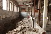 An abandoned section of the mill with rubbish and bricks.