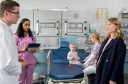 Dr. Elias Bähr (Stefan Ruppe, l.) betreut mit Dr. Emma Jahn (Elisa Agbaglah, 2.v.l.) die hochschwangere Tanja Jakobs (Gabriela Lindl, r.), deren eineinhalb-jährige Tochter Lotte operiert werden muss (mit Komparsin).