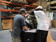 Jose and a Living Color worker lifting rock structure into tank.