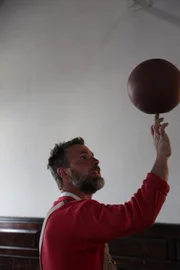 Jay takes a break to play with a basketball he found in the gymnasium.