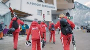 Skilehrerinnen und Skilehrer morgens am Weg zur Gondelbahn.