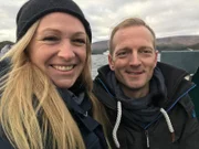 Entertainment-Managerin Corina von Wedel-Gerlach, genannt Cori (links) und der zweite Offizier Christian Baumann fahren beim Stopp in Bonne Bay, Kanada, mit einem Boot zur Schweizer Auswanderin Bettina Lori, die Rettungshunde ausbildet.