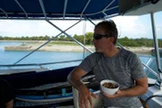 Darrell eats a bowl of cereal on the boat.