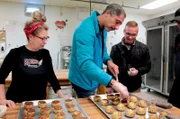 Die Passagiere Raul, von Beruf Flusskreuzfahrtkapitän, und Georgi beim Backen von Fishcakes in der Rocket Bäckerei in St. John's, Neufundland, Kanada.