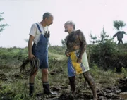 "Aber Herr Lustig, ich nehme doch nur ein Moorbad!", erklärt Lehmann (r.) dem besorgten Peter (l.).