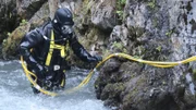 Dustin Hurt in full dive gear in shallow edge of creek.