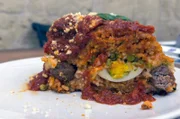 Das neapolitanische Gericht Sartù di riso wird aus Reis, Hackbällchen, Erbsen, Pecorino und Tomatensoße zubereitet.