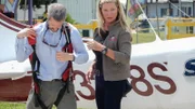 Valerie Kennedy helps the debtor into his parachute.