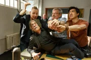 (V.l.n.r.) Vicky Adam (Katja Danowski), Edwin Bremer (Tilo Prückner), Günter Hoffmann (Wolfgang Winkler) und Hui Ko (Aaron Le) rangeln um die einzige Karte für den Polizeiball. Plocher (Michael Prelle, im HG) ist fassungslos und beschließt, einen Mediator einzuschalten.