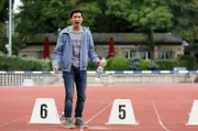 Vicky gibt einen Testschuss ab und trifft die Wasserflasche von Hui Ko (Aaron Le).