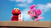 Elmo (l.) und Abby (r.) zaubern mit einer Milchtüte.