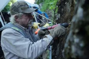 Fred Hurt drills into the solid rock wall.