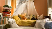 Ella (Anna Menzel) und Rudi (Lennart Morgenstern) haben es sich in der Kuschelecke gemütlich gemacht. Nun sind sie bereit, sich die abenteuerliche Geschichte Stadtbär anzuschauen.