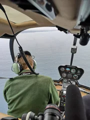 Hubschrauber-Pilot blickt aus seiner Kabine aufs Meer.    +++