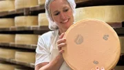 Einstein Schweizer Käse: Was macht ihn so einzigartig? Kathrin Hönegger hält einen Käselaib in der Hand.