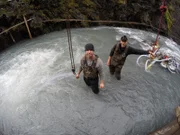 Dustin Hurt and Wes Richardson stand in the creek in low water.
