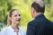 Julia (Mirka Pigulla, l.) hört amüsiert zu, als Berger (Horst Günter Marx, r.) ihr von seinem Ärger mit einer Sommelière erzählt. Zufällig lässt sich diese Weinkennerin gerade im JTK wegen ihres Geschmackverlustes behandeln.