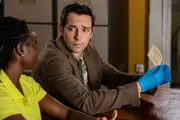 Im Polizeirevier untersuchen Naomi Thomas (Shantol Jackson, l.) und Detective Neville Parker (Ralf Little, r.) akribisch einen Zettel mit einem Hilferuf und führen entsprechende Nachforschungen durch.