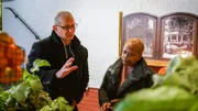 Chef Robert Irvine talks about ingredients with Karen Patton, owner of Sweet Potato Café, in Stone Mountain, GA, as seen on Restaurant: Impossible, Season 20.