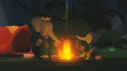 Babar und Badou essen Beeren am Stock beim Lagerfeuer.