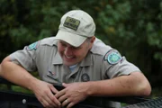 Warden Morgan Inman smiling down into bed of truck