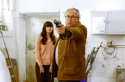Daniela (Alice Gruia, l.) sucht Schutz hinter Klaus (Hartmut Volle, r.), der mit gezogener Waffe, den Entführern entgegentritt.
